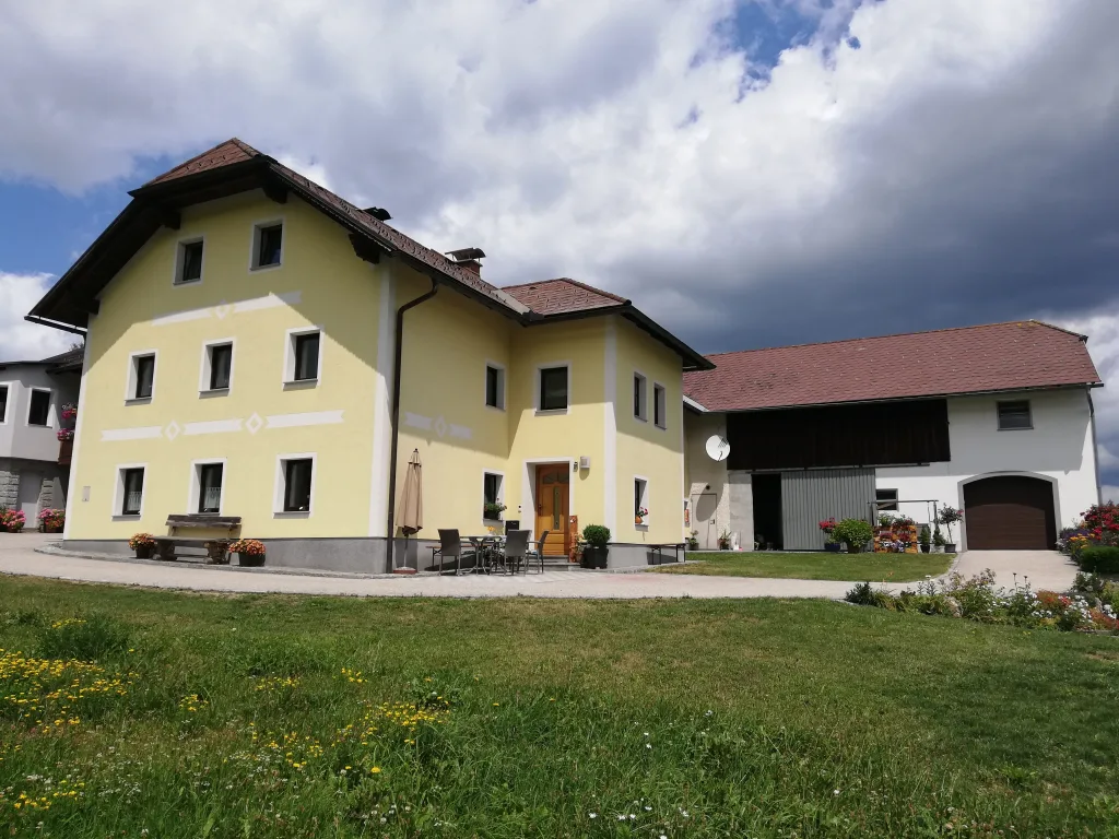 Das gelbe Bauernhaus der Familie Kern in Kaltenberg, davor eine Wiese