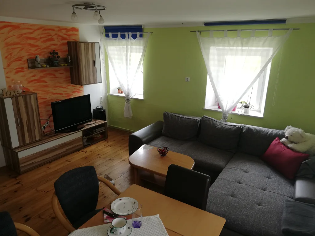Aufenthaltsraum mit Sofa, Fernseher und Esstisch