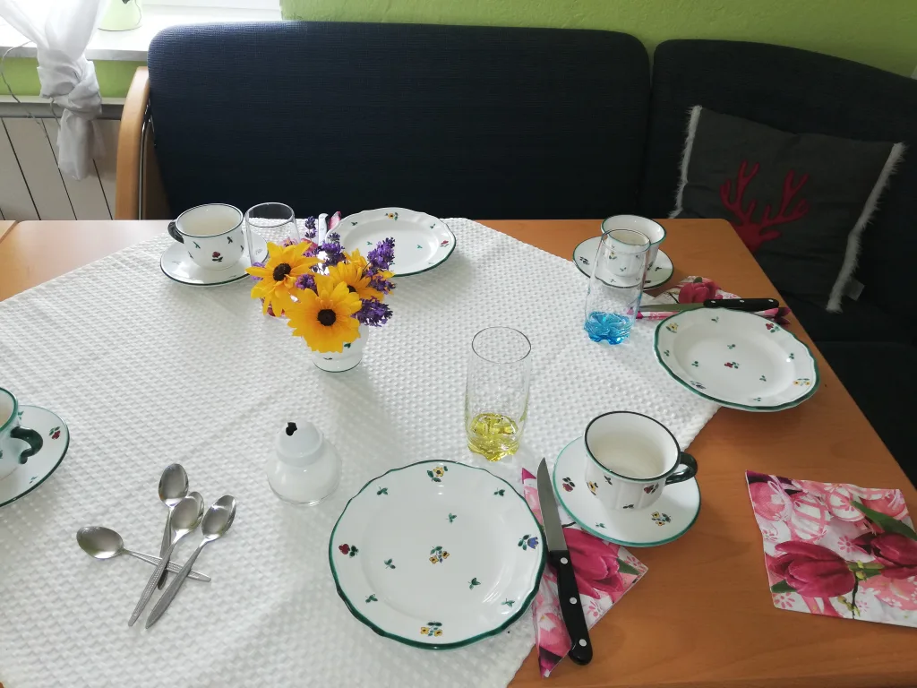 Gedeckter Frühstückstisch mit Blumen und Porzellangeschirr